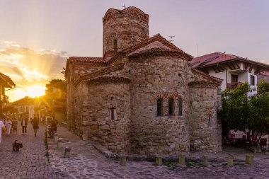 Nesebar, Bulgaristan - 20 Eylül 2023: Bulgaristan 'ın eski Nesebar kentinde yerel halk ve ziyaretçilerle birlikte Aziz Yahya Kilisesi' nin günbatımı manzarası