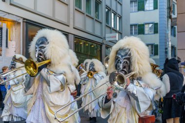 Lucerne, İsviçre - 20 Şubat 2023: Kostüm giymiş müzisyenler ve Fasnacht Karnavalı 'nın bir parçası olan kalabalık, İsviçre' nin başkenti Lucerne 'de yürüyüşe geçti.