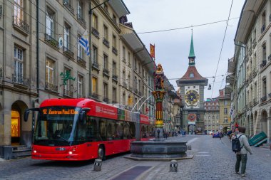 Bern, İsviçre - 22 Şubat 2023: Zahringerbrunnen çeşmesi, Zytglogge saat kulesi, Bern, İsviçre 'deki yerel saat kulesi ve ziyaretçileri ile Kramgasse caddesinin manzarası