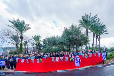 Hayfa, İsrail - 14 Ocak 2024: Hamas saldırısının 100. gününde çeşitli tabela ve bayraklara sahip insanlar rehinelerin serbest bırakılması çağrısında bulundu. Hayfa, İsrail