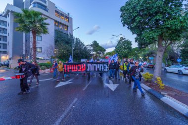 Hayfa, İsrail - 27 Ocak 2024: İnsanlar hükümeti protesto etmek için çeşitli tabela ve bayraklarla yürüyüş yaparak yeni seçimler çağrısında bulundu. Hayfa, İsrail