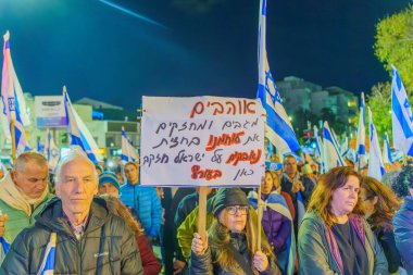 Hayfa, İsrail - 27 Ocak 2024: Hükümeti protesto eden, savaşın sorumluluğunu üstlenen ve rehinelerin serbest bırakılması çağrısında bulunan çeşitli tabela ve bayrakları olan insanlar. Hayfa, İsrail