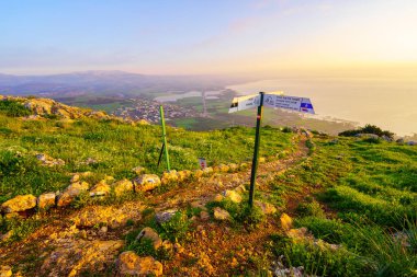 Arbel, İsrail - 09 Şubat 2024: Galilee Denizi 'nin gün doğumu manzarası, ve Arbel Doğa Rezervi, bir patika ve yön işareti ile, Kuzey İsrail