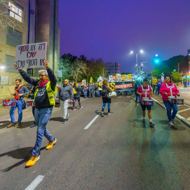 Hayfa, İsrail - 02 Mart 2024: İnsanlar, hükümete karşı çeşitli tabelalar ve bayraklarla yeni seçimler çağrısında bulunan bir protesto yürüyüşüne katıldılar. Hayfa, İsrail