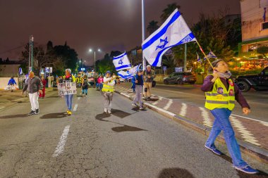 Hayfa, İsrail - 02 Mart 2024: İnsanlar, hükümete karşı çeşitli tabelalar ve bayraklarla yeni seçimler çağrısında bulunan bir protesto yürüyüşüne katıldılar. Hayfa, İsrail