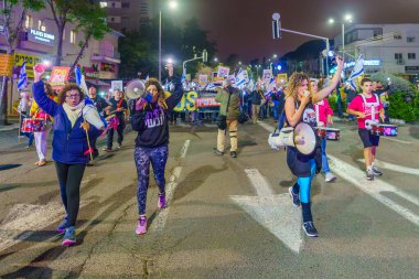 Hayfa, İsrail - 02 Mart 2024: İnsanlar, hükümete karşı çeşitli tabelalar ve bayraklarla yeni seçimler çağrısında bulunan bir protesto yürüyüşüne katıldılar. Hayfa, İsrail