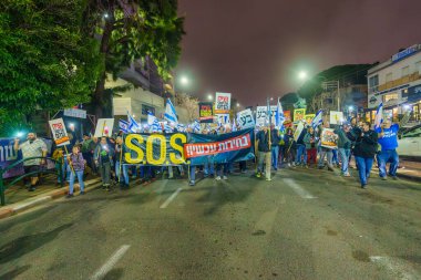 Hayfa, İsrail - 02 Mart 2024: İnsanlar, hükümete karşı çeşitli tabelalar ve bayraklarla yeni seçimler çağrısında bulunan bir protesto yürüyüşüne katıldılar. Hayfa, İsrail