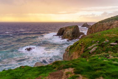 İngiltere, Cornwall 'da bulunan Longships Lighthouse ile Lands End kıyı şeridi manzarasının günbatımı