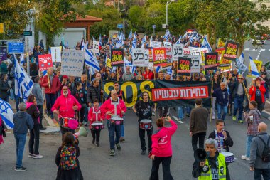 Hayfa, İsrail - 16 Mart 2024: İnsanlar hükümete karşı çeşitli tabelalar ve bayraklarla bir protesto yürüyüşüne katılarak yeni seçimler çağrısında bulundu. Hayfa, İsrail