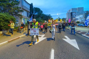 Hayfa, İsrail - 16 Mart 2024: İnsanlar hükümete karşı çeşitli tabelalar ve bayraklarla bir protesto yürüyüşüne katılarak yeni seçimler çağrısında bulundu. Hayfa, İsrail