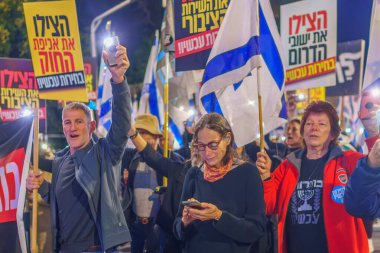 Hayfa, İsrail - 16 Mart 2024: İnsanlar hükümete karşı çeşitli tabelalar ve bayraklarla bir protesto yürüyüşüne katılarak yeni seçimler çağrısında bulundu. Hayfa, İsrail