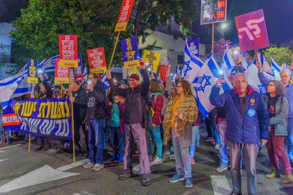 Hayfa, İsrail - 23 Mart 2024: İnsanlar, hükümete karşı çeşitli tabelalar ve bayraklarla yeni seçimler çağrısında bulunan bir protesto yürüyüşüne katıldılar. Hayfa, İsrail
