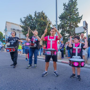 Hayfa, İsrail - 30 Mart 2024: İnsanlar, hükümete karşı çeşitli tabelalar ve bayraklarla yeni seçimler çağrısında bulunan bir protesto yürüyüşüne katılıyor. Hayfa, İsrail