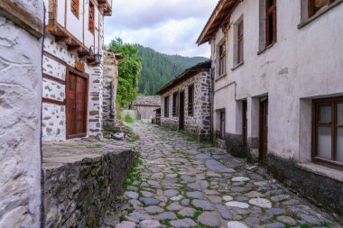 Shiroka Laka, Bulgaristan - 26 Eylül 2023: Bulgaristan 'ın güneyindeki Shiroka Laka, Rodop Dağları' nda tipik binalara sahip bir caddenin gün batımı manzarası