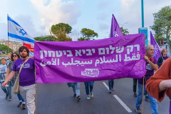 stock image Haifa, Israel - April 06, 2024: People with signs calling for peace talk, ceasefire and hostage deal, part of a protest march, Haifa, Israel