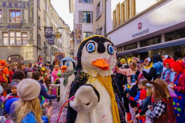 Lucerne, İsviçre - 21 Şubat 2023: Kostüm giymiş bir grup katılımcı ve kalabalık, İsviçre 'nin Lucerne kentinde düzenlenen Fasnacht Karnavalı' nın çocuk geçit töreninin bir parçası.