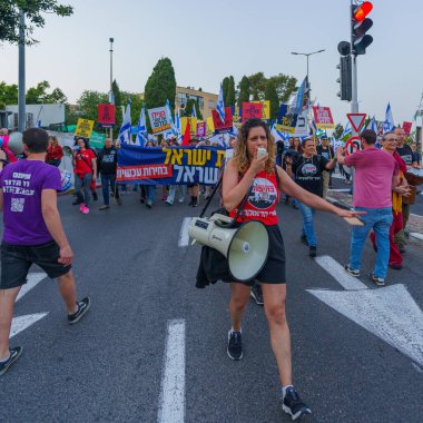 Hayfa, İsrail - 20 Nisan 2024: İnsanlar hükümete karşı çeşitli tabelalar ve bayraklarla yeni seçimler çağrısında bulunarak bir protesto yürüyüşüne katılıyor. Hayfa, İsrail