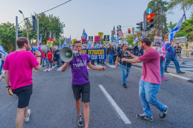 Hayfa, İsrail - 20 Nisan 2024: İnsanlar hükümete karşı çeşitli tabelalar ve bayraklarla yeni seçimler çağrısında bulunarak bir protesto yürüyüşüne katılıyor. Hayfa, İsrail