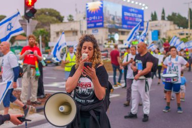 Hayfa, İsrail - 27 Nisan 2024: İnsanlar hükümete karşı çeşitli tabela ve bayraklarla bir protesto yürüyüşüne katılarak yeni seçimler çağrısında bulundu. Hayfa, İsrail
