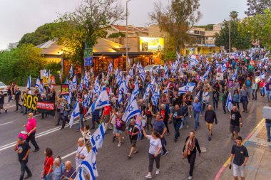 Hayfa, İsrail - 27 Nisan 2024: İnsanlar hükümete karşı çeşitli tabela ve bayraklarla bir protesto yürüyüşüne katılarak yeni seçimler çağrısında bulundu. Hayfa, İsrail