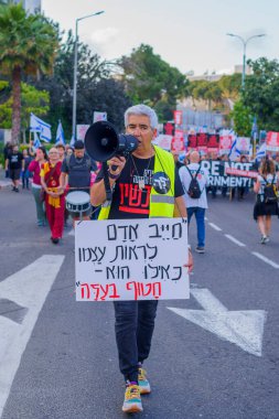 Hayfa, İsrail - 04 Mayıs 2024: İnsanlar, hükümete karşı çeşitli tabelalar ve bayraklarla yeni seçimler çağrısında bulunan bir protesto yürüyüşüne katıldılar. Hayfa, İsrail