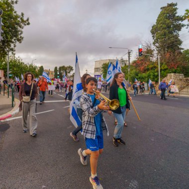 Hayfa, İsrail - 04 Mayıs 2024: İnsanlar, hükümete karşı çeşitli tabelalar ve bayraklarla yeni seçimler çağrısında bulunan bir protesto yürüyüşüne katıldılar. Hayfa, İsrail