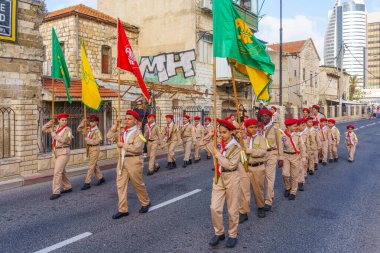 Hayfa, İsrail - 4 Mayıs 2024: Yerel Arap Ortodoks Hıristiyan izciler Paskalya Kutsal Cumartesisini bir geçit töreniyle kutluyorlar. Hayfa şehir merkezi, İsrail