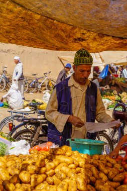 Rissani, Morocco - April 02, 2023: Market scene, with vegetable stalls, sellers, and shoppers, in Rissani, Sahara Desert, Morocco clipart
