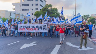 Hayfa, İsrail - 11 Mayıs 2024: İnsanlar hükümete karşı çeşitli tabelalar ve bayraklarla bir protesto yürüyüşüne katılarak yeni seçimler çağrısında bulundu. Hayfa, İsrail