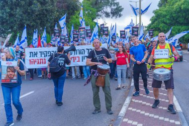 Hayfa, İsrail - 11 Mayıs 2024: İnsanlar hükümete karşı çeşitli tabelalar ve bayraklarla bir protesto yürüyüşüne katılarak yeni seçimler çağrısında bulundu. Hayfa, İsrail