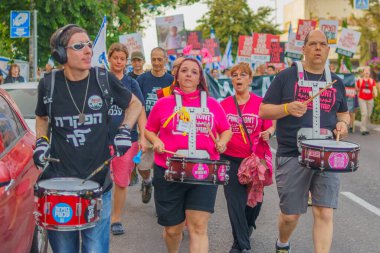 Hayfa, İsrail - 18 Mayıs 2024: İnsanlar, hükümete karşı çeşitli tabelalar ve bayraklarla yeni seçimler çağrısında bulunan bir protesto yürüyüşüne katılıyor. Hayfa, İsrail
