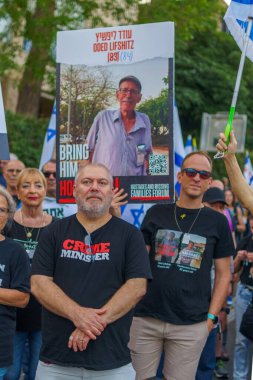 Hayfa, İsrail - 18 Mayıs 2024: İnsanlar, hükümete karşı çeşitli tabelalar ve bayraklarla yeni seçimler çağrısında bulunan bir protesto yürüyüşüne katılıyor. Hayfa, İsrail