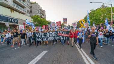 Hayfa, İsrail - 18 Mayıs 2024: İnsanlar, hükümete karşı çeşitli tabelalar ve bayraklarla yeni seçimler çağrısında bulunan bir protesto yürüyüşüne katılıyor. Hayfa, İsrail