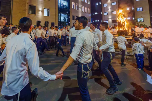 Hayfa, İsrail - 25 Mayıs 2024: Ultra-Ortodoks Yahudiler, İsrail 'in Hayfa kentinde bir ateşin yanında dans ederek Geleneksel Lag-BaOmer Bayramını kutladılar