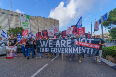 Hayfa, İsrail - 25 Mayıs 2024: İnsanlar, hükümete karşı çeşitli tabelalar ve bayraklarla yeni seçimler çağrısında bulunan bir protesto yürüyüşüne katıldılar. Hayfa, İsrail