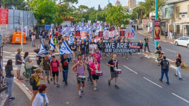 Hayfa, İsrail - 25 Mayıs 2024: İnsanlar, hükümete karşı çeşitli tabelalar ve bayraklarla yeni seçimler çağrısında bulunan bir protesto yürüyüşüne katıldılar. Hayfa, İsrail