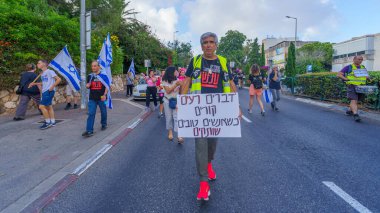Hayfa, İsrail - 25 Mayıs 2024: İnsanlar, hükümete karşı çeşitli tabelalar ve bayraklarla yeni seçimler çağrısında bulunan bir protesto yürüyüşüne katıldılar. Hayfa, İsrail