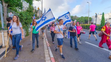 Hayfa, İsrail - 25 Mayıs 2024: İnsanlar, hükümete karşı çeşitli tabelalar ve bayraklarla yeni seçimler çağrısında bulunan bir protesto yürüyüşüne katıldılar. Hayfa, İsrail