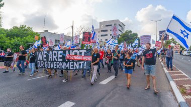 Hayfa, İsrail - 25 Mayıs 2024: İnsanlar, hükümete karşı çeşitli tabelalar ve bayraklarla yeni seçimler çağrısında bulunan bir protesto yürüyüşüne katıldılar. Hayfa, İsrail