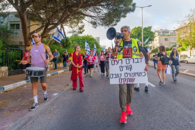 Hayfa, İsrail - 25 Mayıs 2024: İnsanlar, hükümete karşı çeşitli tabelalar ve bayraklarla yeni seçimler çağrısında bulunan bir protesto yürüyüşüne katıldılar. Hayfa, İsrail