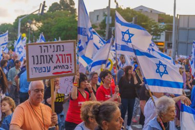 Hayfa, İsrail - 25 Mayıs 2024: Çeşitli tabela ve bayraklara sahip bir kalabalık hükümeti protesto ederek yeni seçim çağrısında bulundu. Hayfa, İsrail