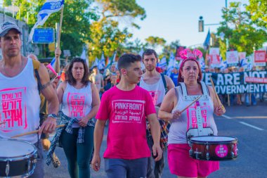 Hayfa, İsrail - 01 Haziran 2024: İnsanlar hükümete karşı çeşitli tabelalar ve bayraklarla yeni seçimler çağrısında bulunarak bir protesto yürüyüşüne katılıyor. Hayfa, İsrail