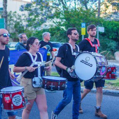 Hayfa, İsrail - 01 Haziran 2024: İnsanlar hükümete karşı çeşitli tabelalar ve bayraklarla yeni seçimler çağrısında bulunarak bir protesto yürüyüşüne katılıyor. Hayfa, İsrail