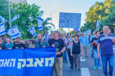 Hayfa, İsrail - 01 Haziran 2024: İnsanlar hükümete karşı çeşitli tabelalar ve bayraklarla yeni seçimler çağrısında bulunarak bir protesto yürüyüşüne katılıyor. Hayfa, İsrail