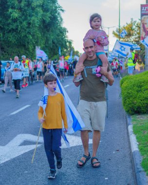 Hayfa, İsrail - 01 Haziran 2024: İnsanlar hükümete karşı çeşitli tabelalar ve bayraklarla yeni seçimler çağrısında bulunarak bir protesto yürüyüşüne katılıyor. Hayfa, İsrail