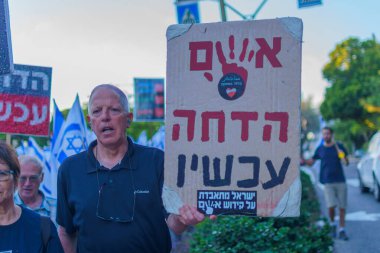 Hayfa, İsrail - 01 Haziran 2024: İnsanlar hükümete karşı çeşitli tabelalar ve bayraklarla yeni seçimler çağrısında bulunarak bir protesto yürüyüşüne katılıyor. Hayfa, İsrail