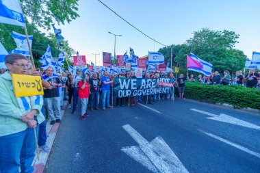 Hayfa, İsrail - 01 Haziran 2024: İnsanlar hükümete karşı çeşitli tabelalar ve bayraklarla yeni seçimler çağrısında bulunarak bir protesto yürüyüşüne katılıyor. Hayfa, İsrail