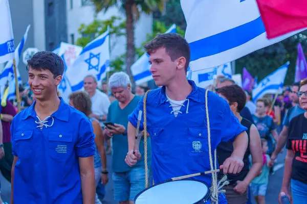 Stock image Haifa, Israel - June 01, 2024: People take part in a protest march, with various signs and flags, against the government, calling for new elections. Haifa, Israel