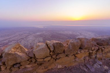 Masada Kalesi 'nin ve Ölü Deniz' in, İsrail 'in güneyindeki Judaean Çölü' nün kalıntılarının gündoğumu manzarası