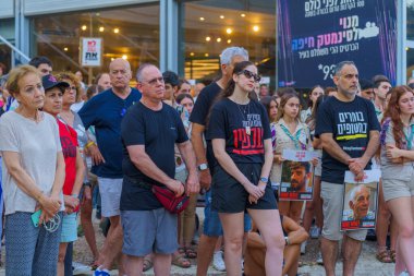 Hayfa, İsrail - Haziran 06, 2024: Rehine ailelerine destek veren ve İsrail 'in Hayfa kentinde bir rehine anlaşması için çağrıda bulunan çeşitli tabela ve bayraklı kalabalık